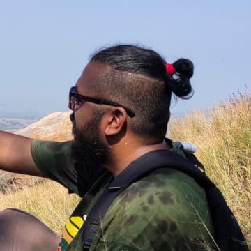 Lohit Roshan Murthy sitting on a grassy hillside